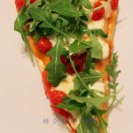 Pizza with mozzarella, caramelized cherry tomatoes and arugula